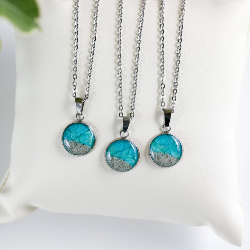 Ogrlice z okroglim obeskom v turkizno zeleni barvi in peskom iz reke Soče na srebrni verižici iz nerjavečega jekla – kolekcija Soča.