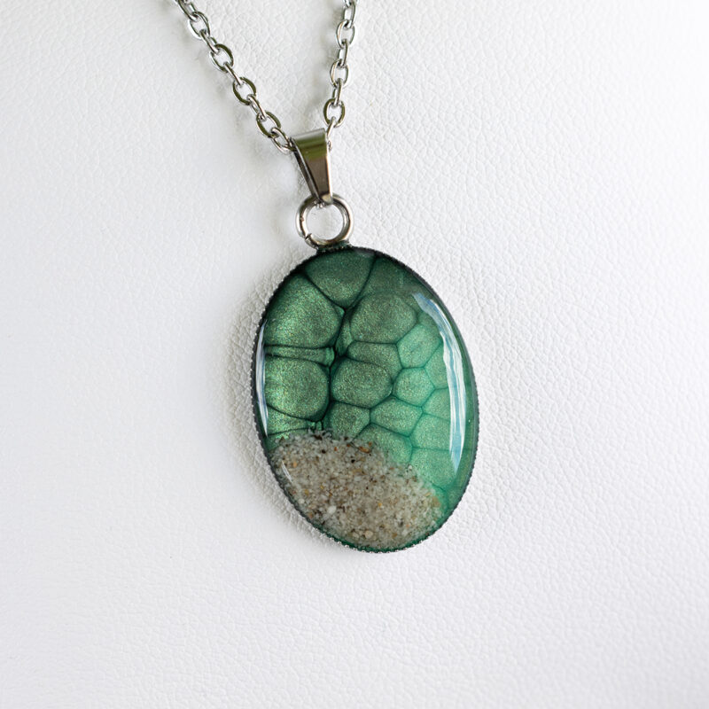 Ogrlica z ovalnim zelenim medaljonom, peskom iz reke Soče in sijočo smolo – ročno izdelano darilo za ljubiteljice narave.