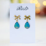 Praznični uhani Soča kapljice s peskom reke Soče in pozlačeno mašnico