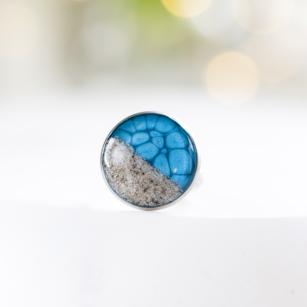 prstan-soca-moder-okrogli-m-2cm (3) Ročno izdelan moder prstan Soča z motivom peska iz reke Soče, premera 2 cm, z nastavljivo osnovo iz nerjavečega jekla.