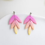 Ročno izdelani viseči uhani iz polimerne gline v roza in rumeni barvi.