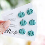 Neviseči uhani v obliki bučk v evkaliptus zeleni barvi z nežnim leskom, izdelani iz polimerne gline z jekleno osnovo.