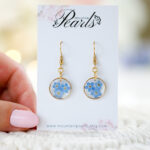 Ročno izdelani viseči uhani z modrimi spominčicami v zlati okrogli osnovi iz medenine in nerjavečega jekla
