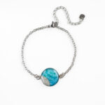 Zapestnica Soča v turkiznih tonih z drobnim peskom iz reke Soče, ročno izdelana iz nerjavečega jekla.