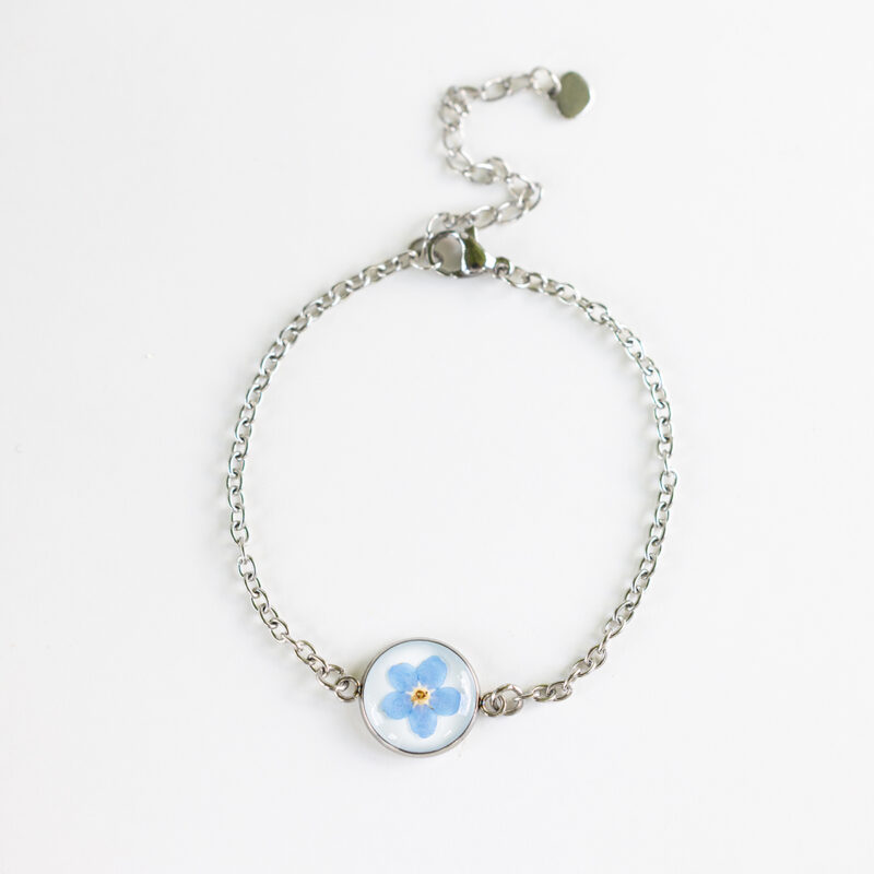Zapestnica z nežno modro spominčico, ujeta v medaljon iz jekla, s tanko verižico iz nerjavečega jekla